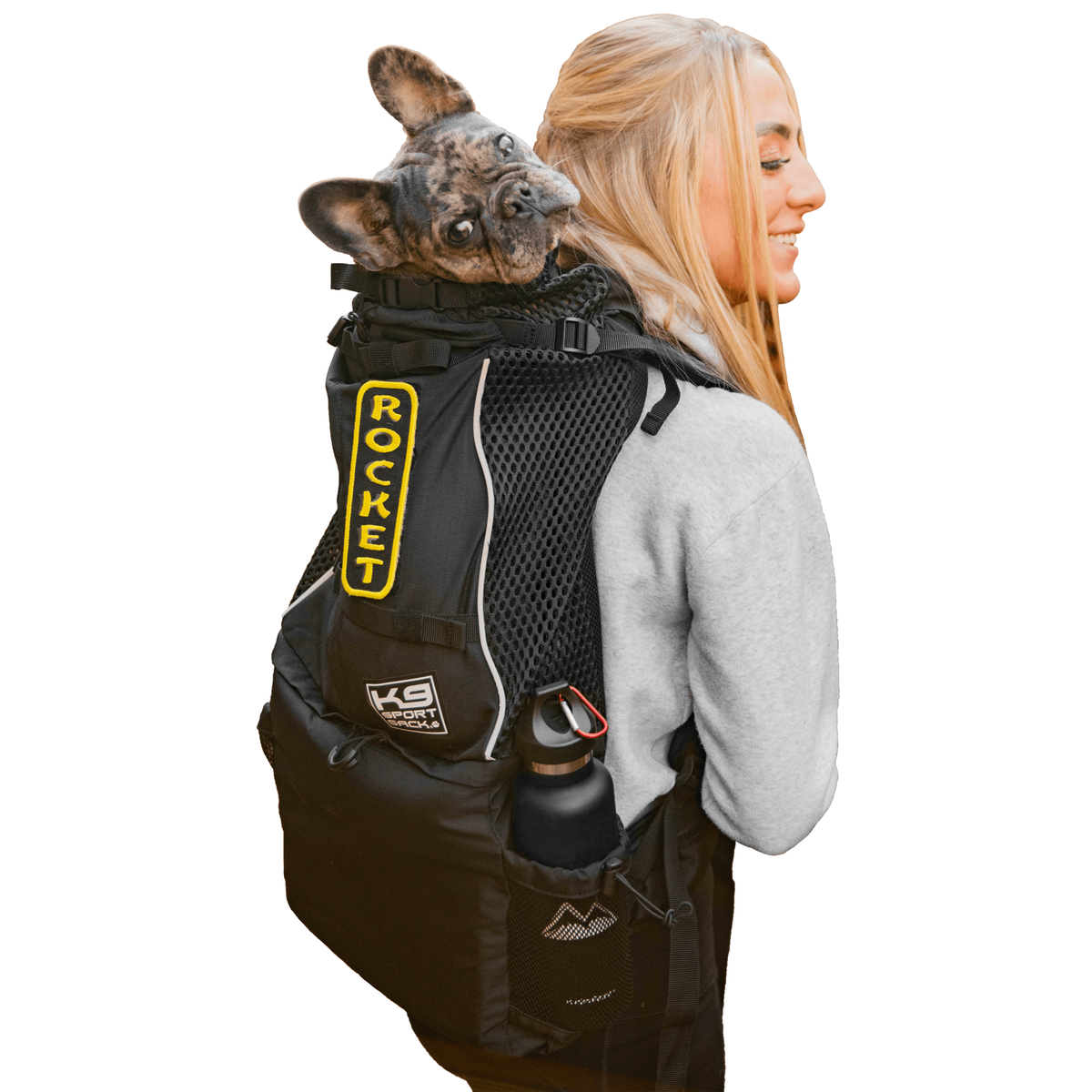 Woman carrying a French bulldog in the black K9 Sport Sack Knavigate dog carrier backpack