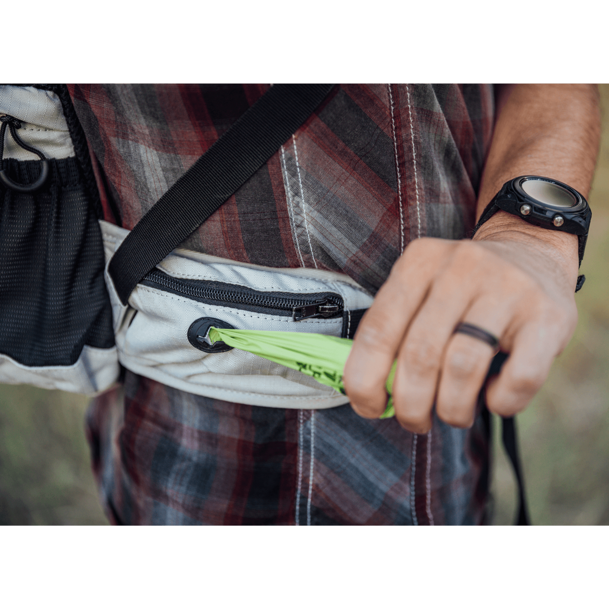 Close-up of a hand pulling a leash out of the hip pocket on the Knavigate dog carrier backpack