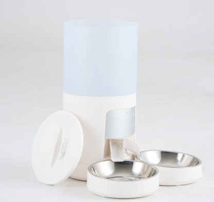 White automatic pet feeder with its lid off beside it, showing the frosted 6-liter hopper